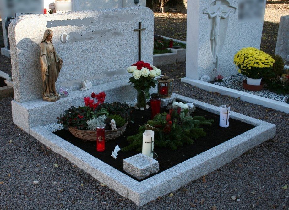 Una tomba in un cimitero con fiori e candele