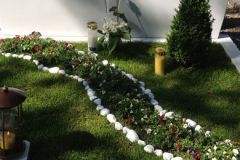 Un prato con una fila di fiori e candele.