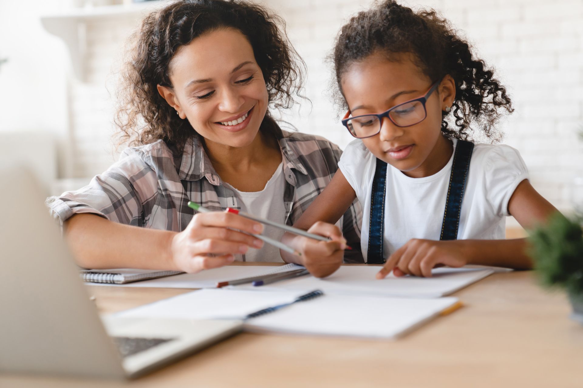 Woman and child looking at a notebook together.