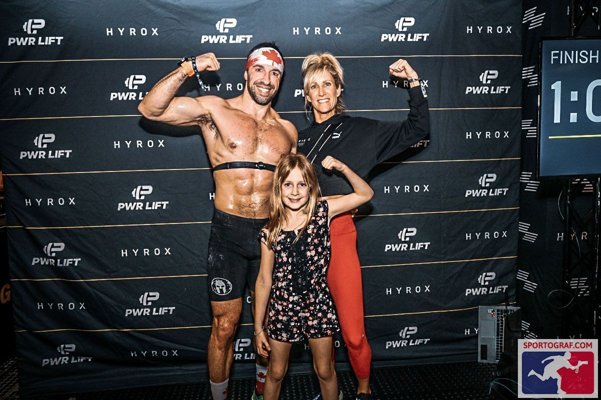 Deux hommes fléchissant leurs muscles devant un panneau indiquant 0:58