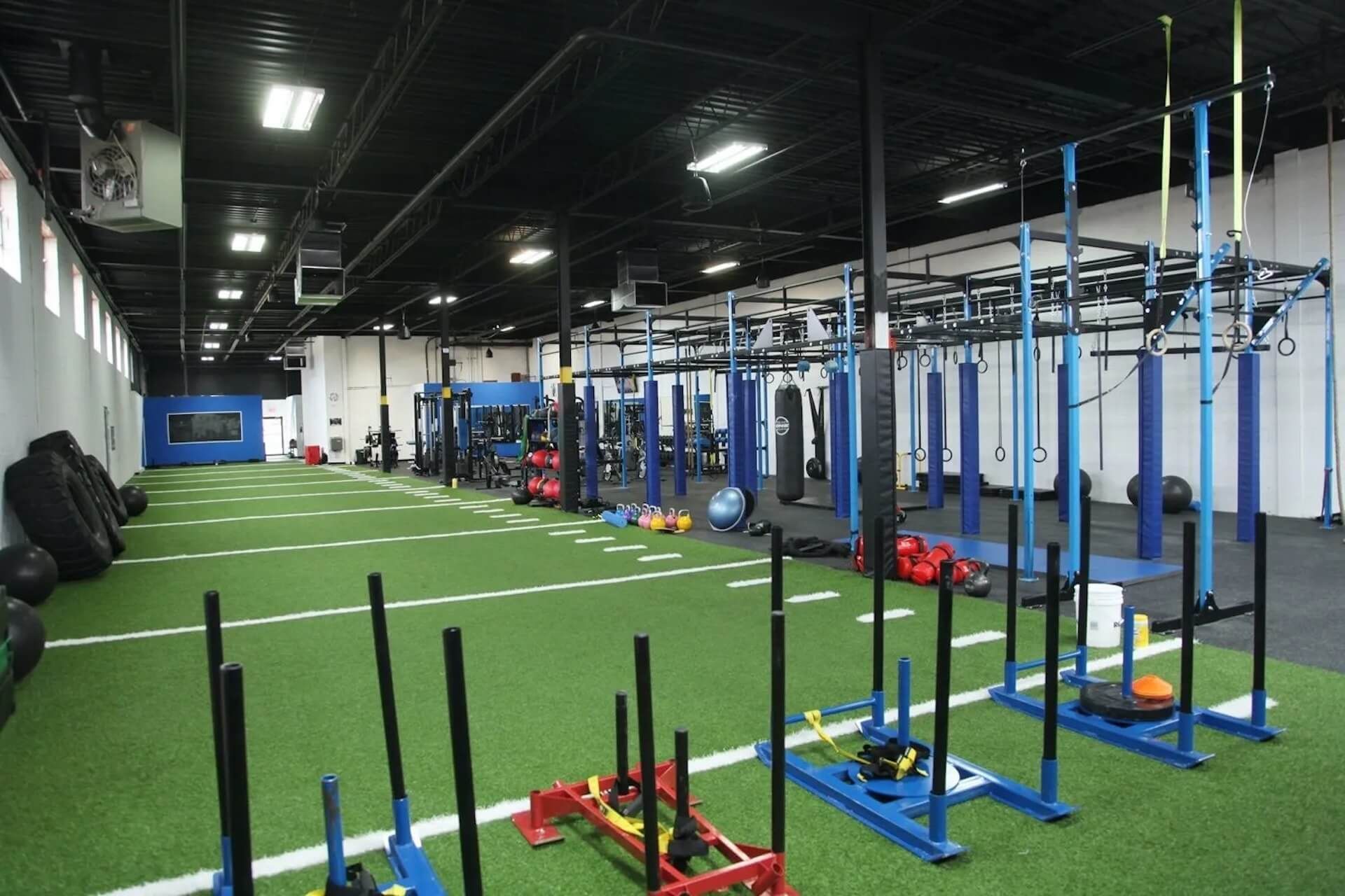 Une grande salle de sport remplie de nombreux équipements d'exercice.