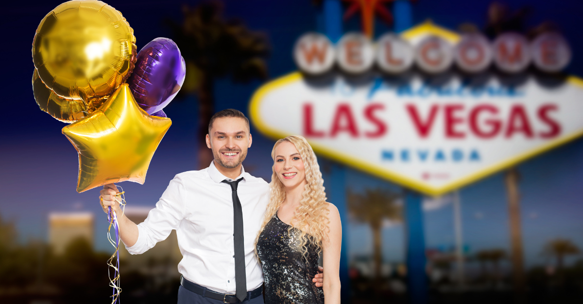 A man and a woman are holding balloons in front of a las vegas sign.