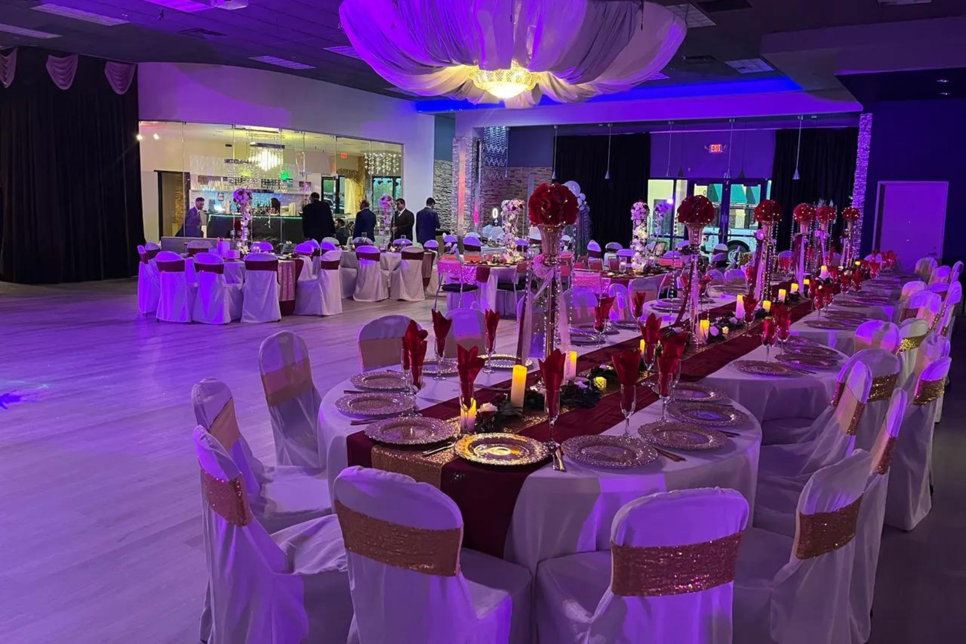 A large room with tables and chairs set up for a wedding reception.