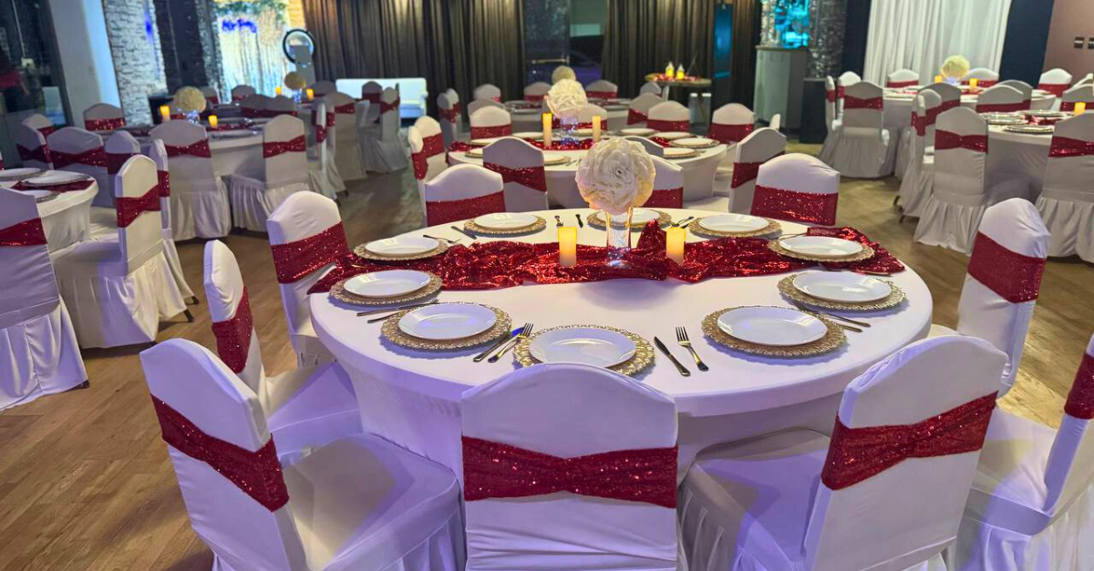 A large room with tables and chairs set up for a wedding reception.