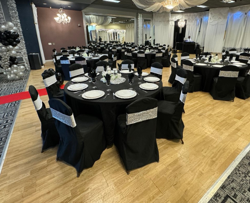 A large room with tables and chairs set up for a wedding reception.