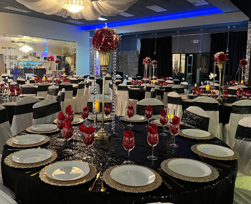 A large room with tables and chairs set up for a wedding reception.