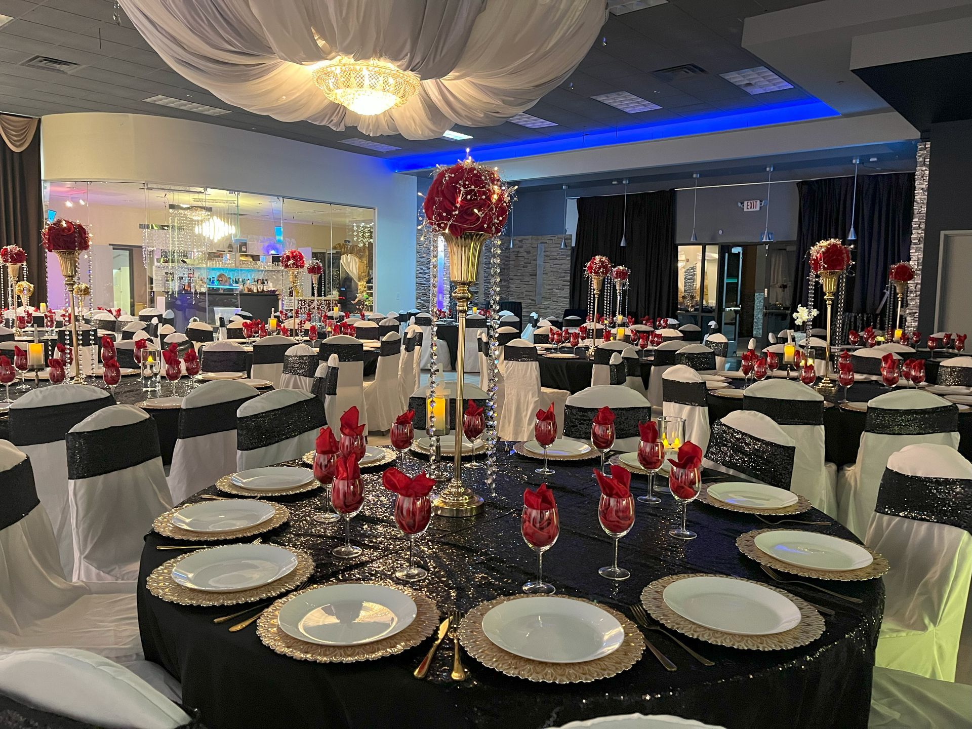 A large room with tables and chairs set up for a wedding reception.