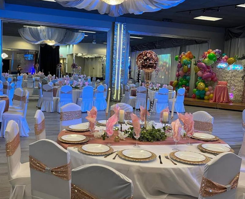 A large room with tables and chairs set up for a wedding reception.