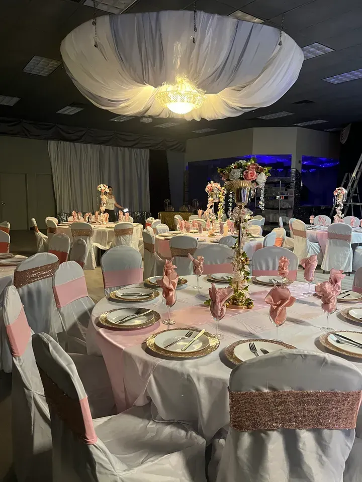 A large room with tables and chairs set up for a wedding reception.