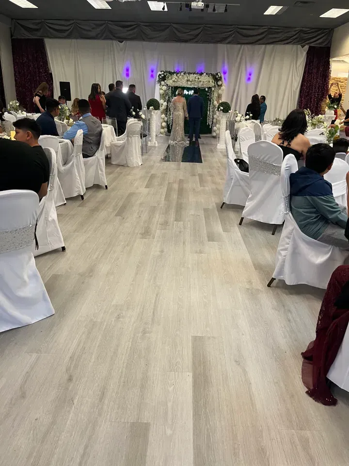A large room with tables and chairs set up for a wedding reception.