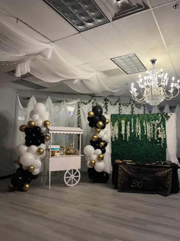 A room filled with balloons and a popcorn cart.