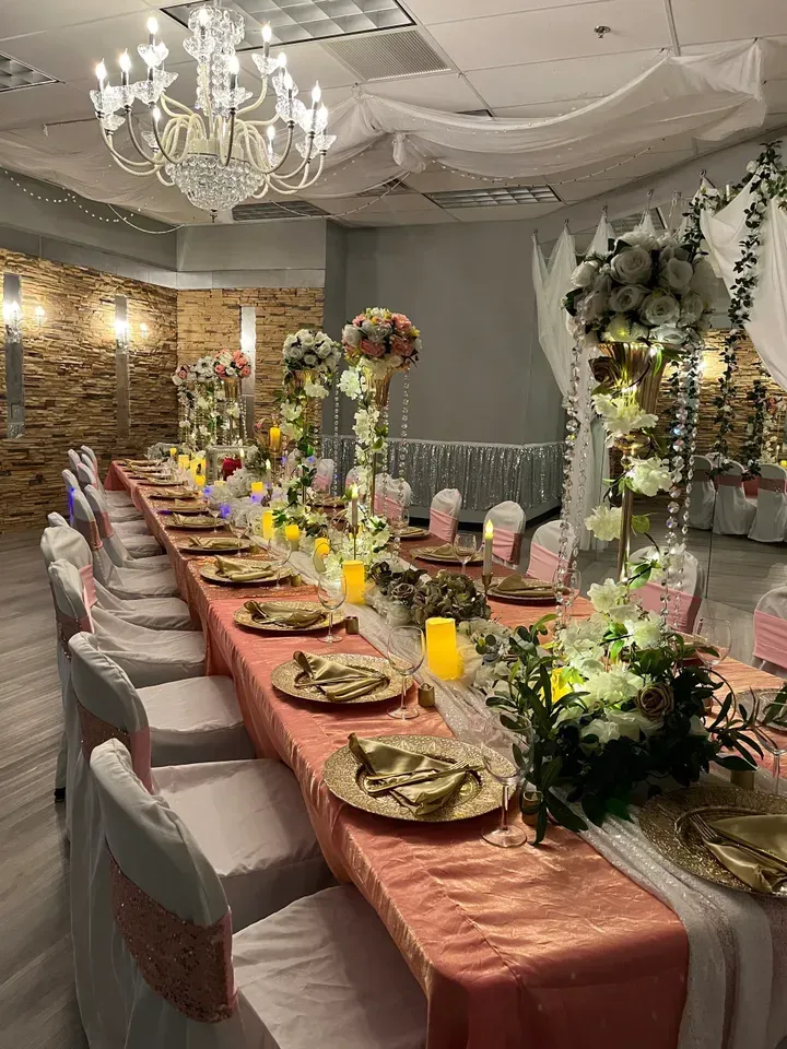 A long table with plates and candles on it in a room.