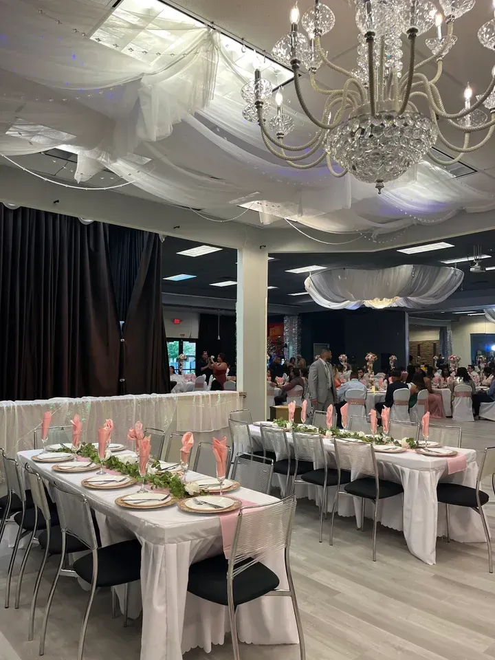 A large room with tables and chairs set up for a wedding reception.