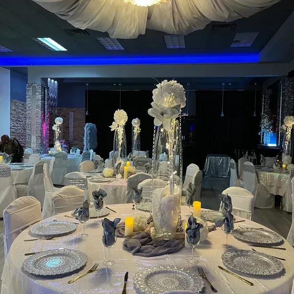 A large room with tables and chairs set up for a wedding reception