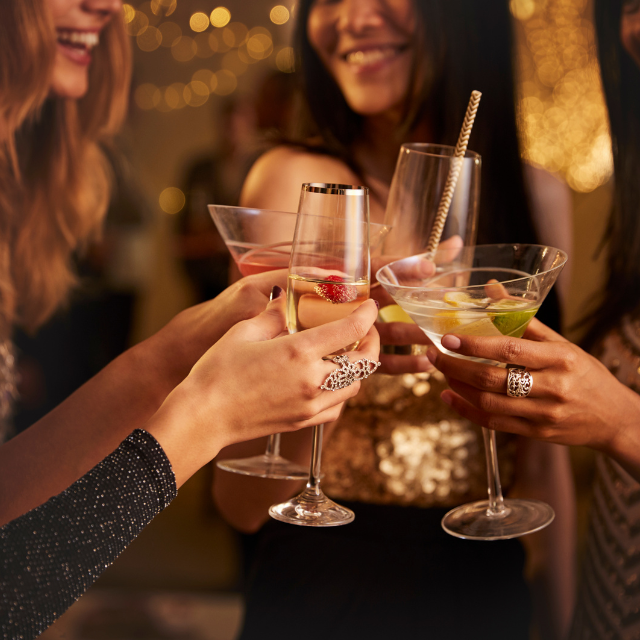A group of women are toasting with martini glasses