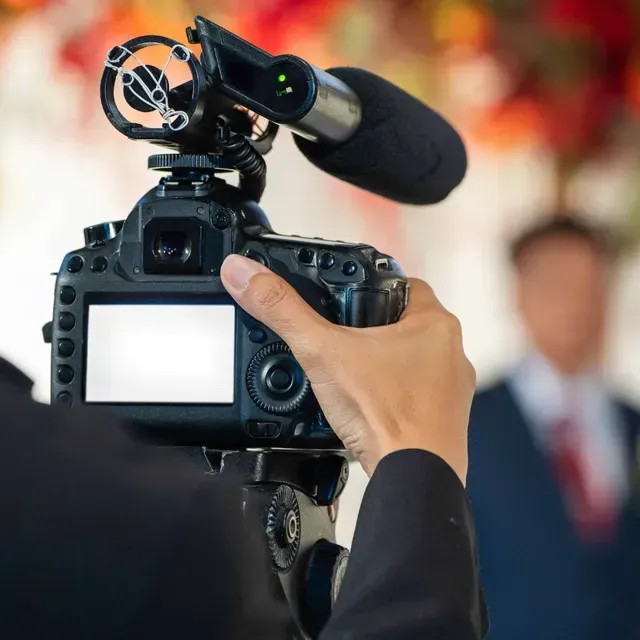 A person is holding a camera with a microphone attached to it
