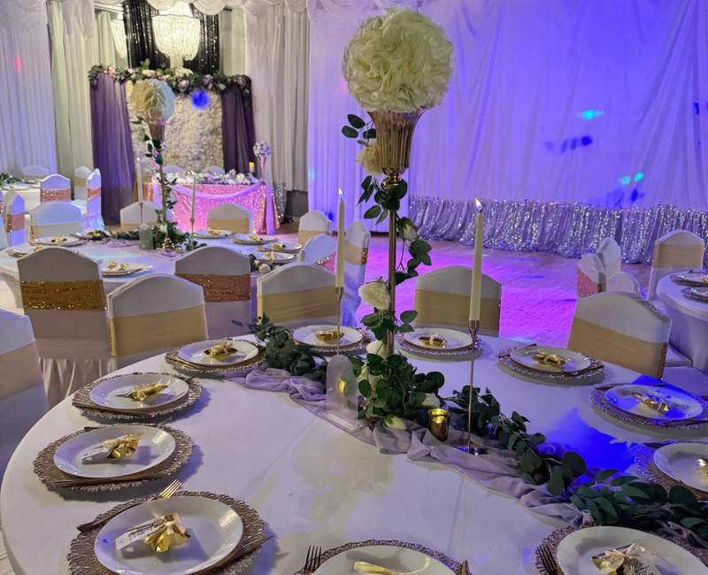 A large room with tables and chairs set up for a wedding reception.