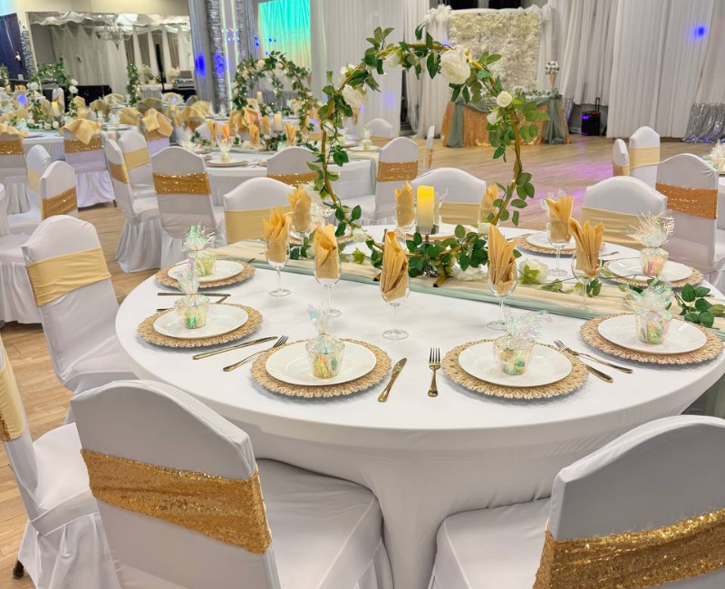 A large room with tables and chairs set up for a wedding reception.