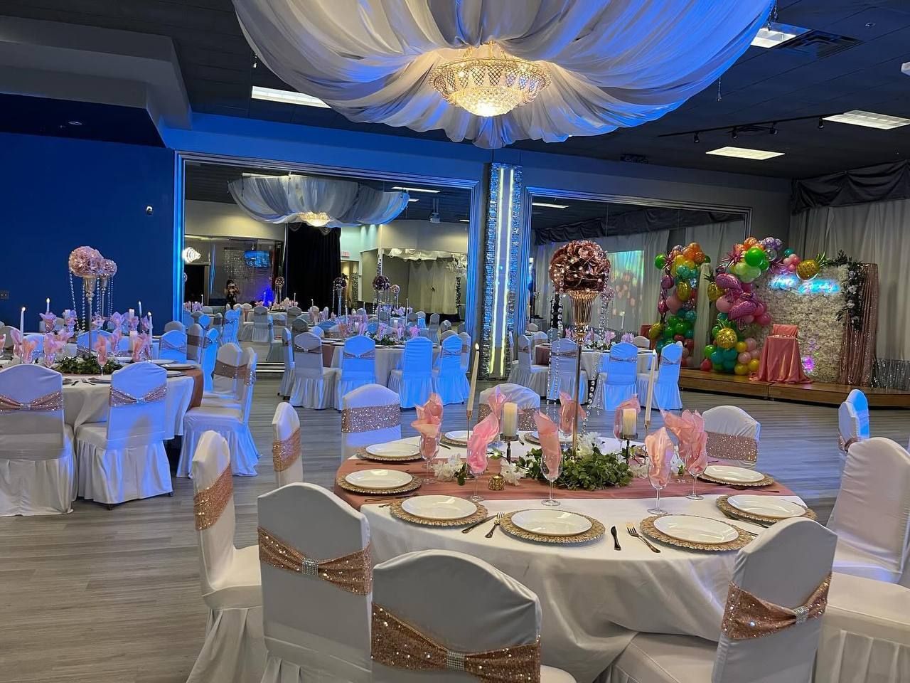 A large room with tables and chairs set up for a wedding reception.