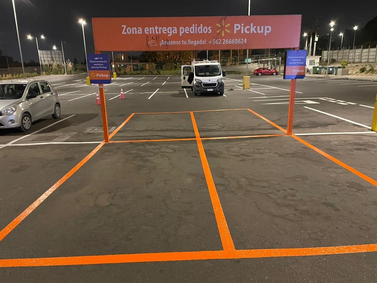Un estacionamiento con un cartel que dice zona entrega pedidos recogida