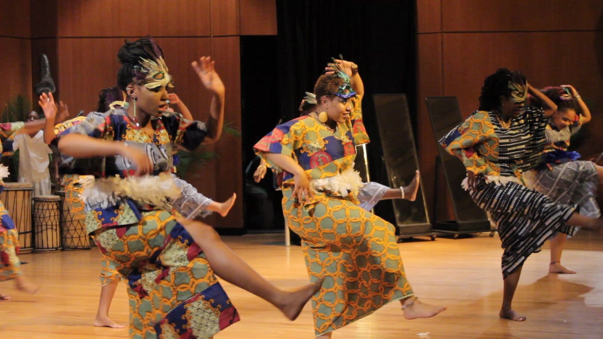 Dancers in colorful African attire perform on stage.
