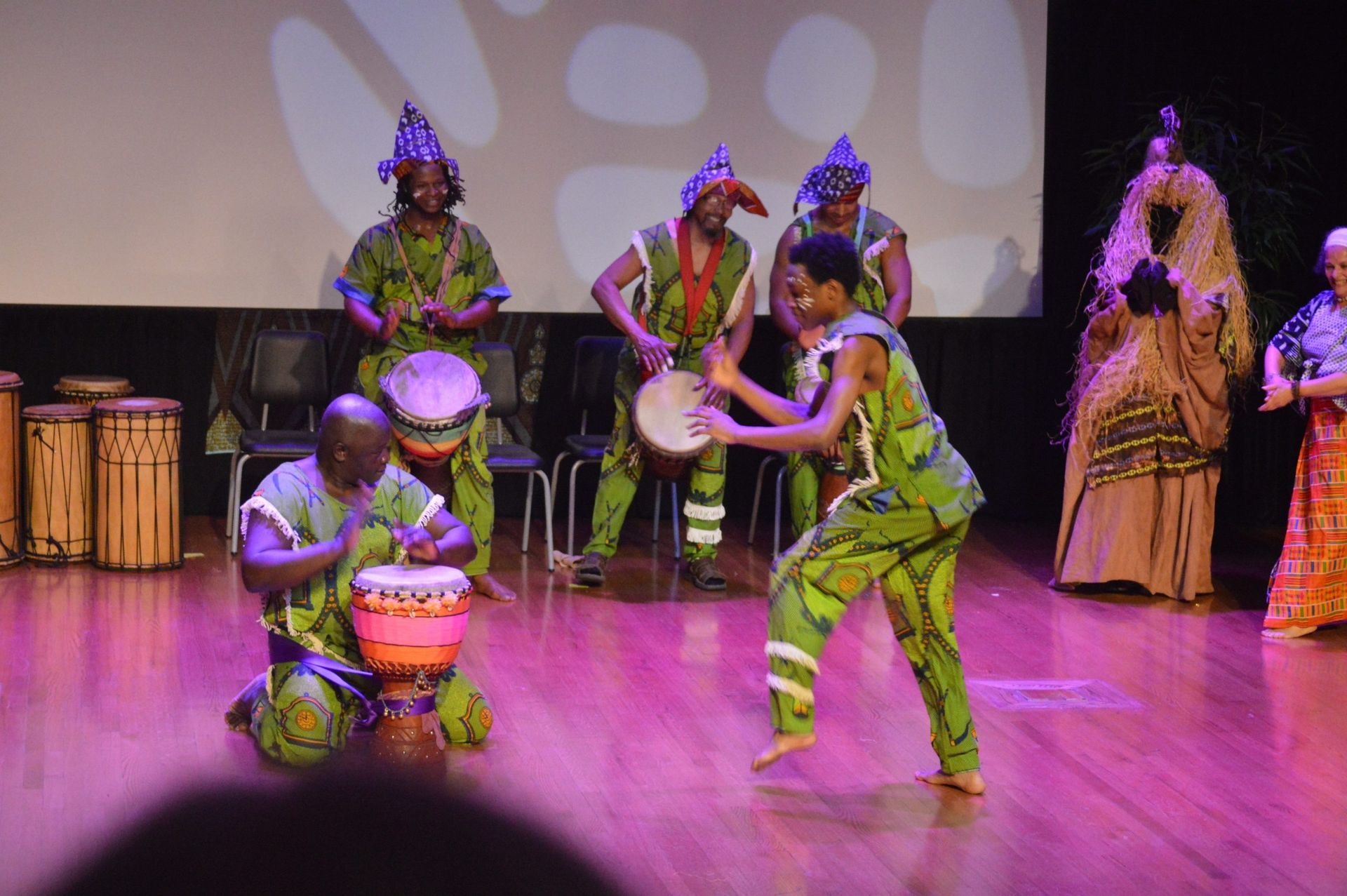 African drummers and dancers performing on stage.