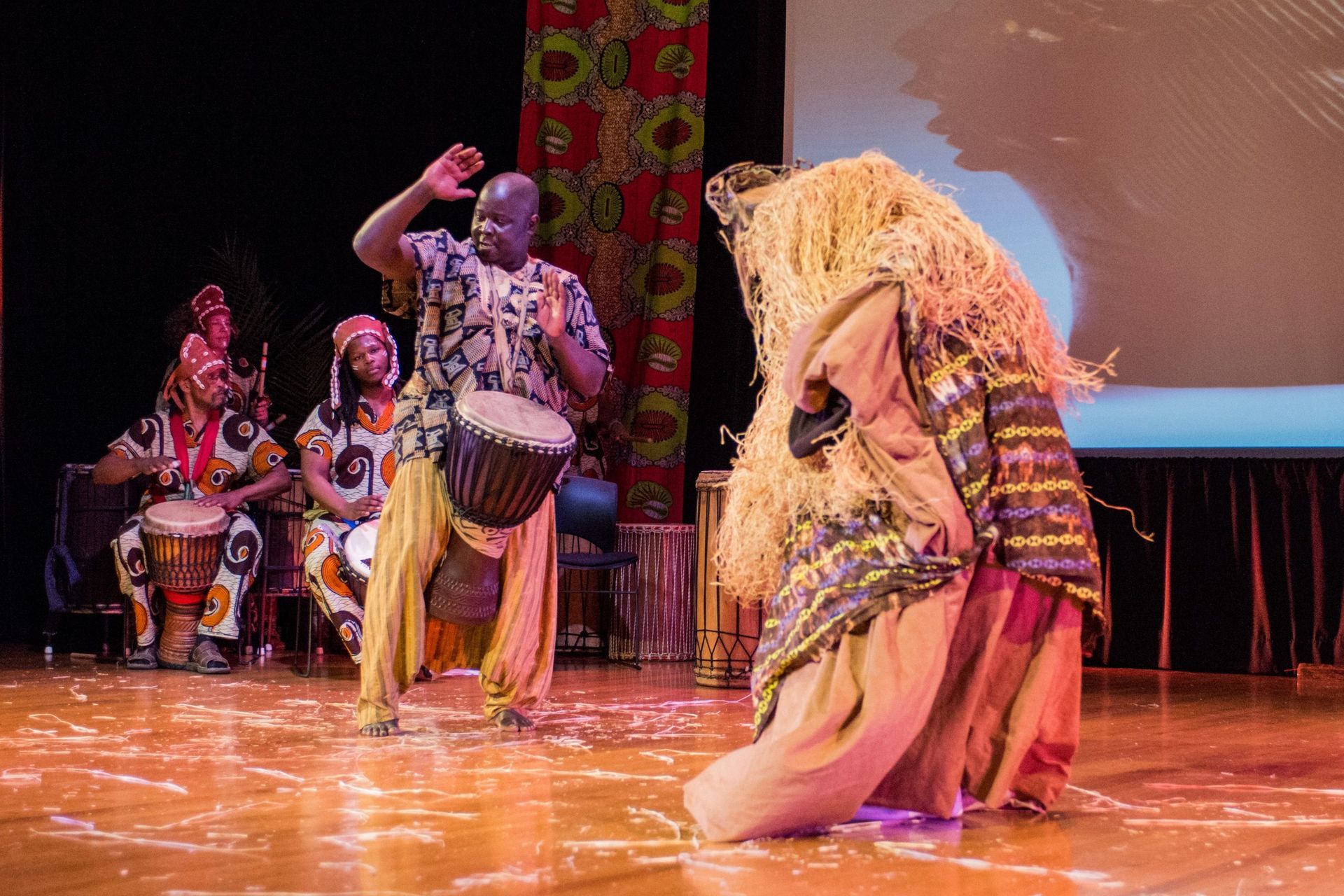 African dancers and drummers perform on stage.