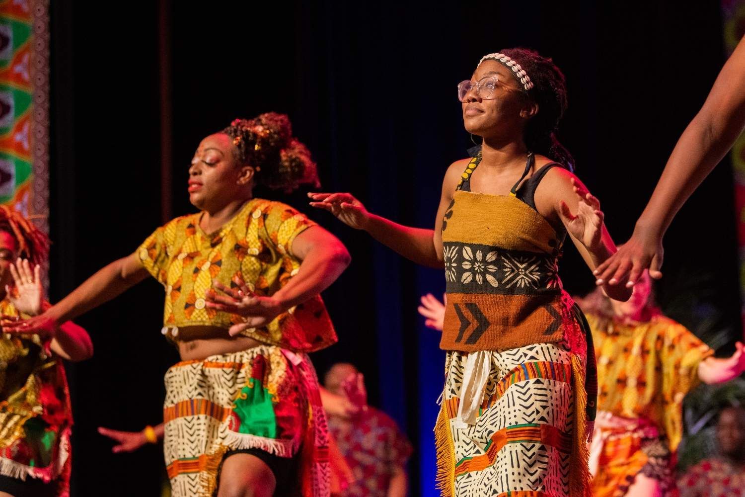 People performing a vibrant African dance on stage
