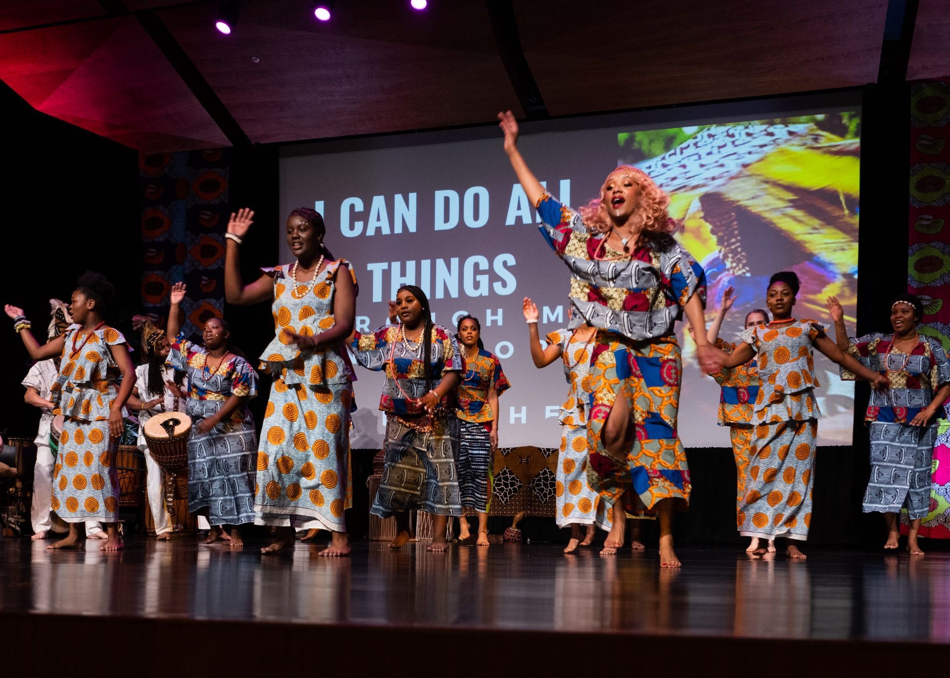 A diverse group of people dance on stage