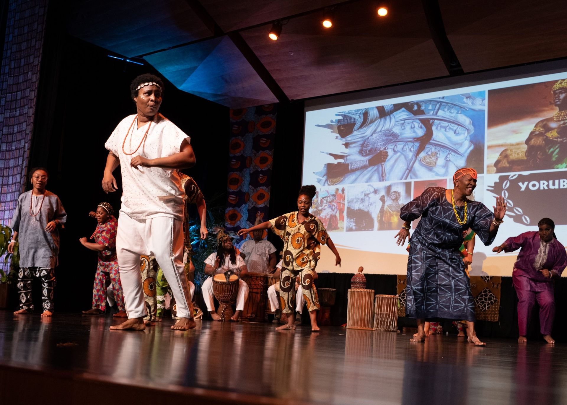 People of African descent performing on stage with a backdrop
