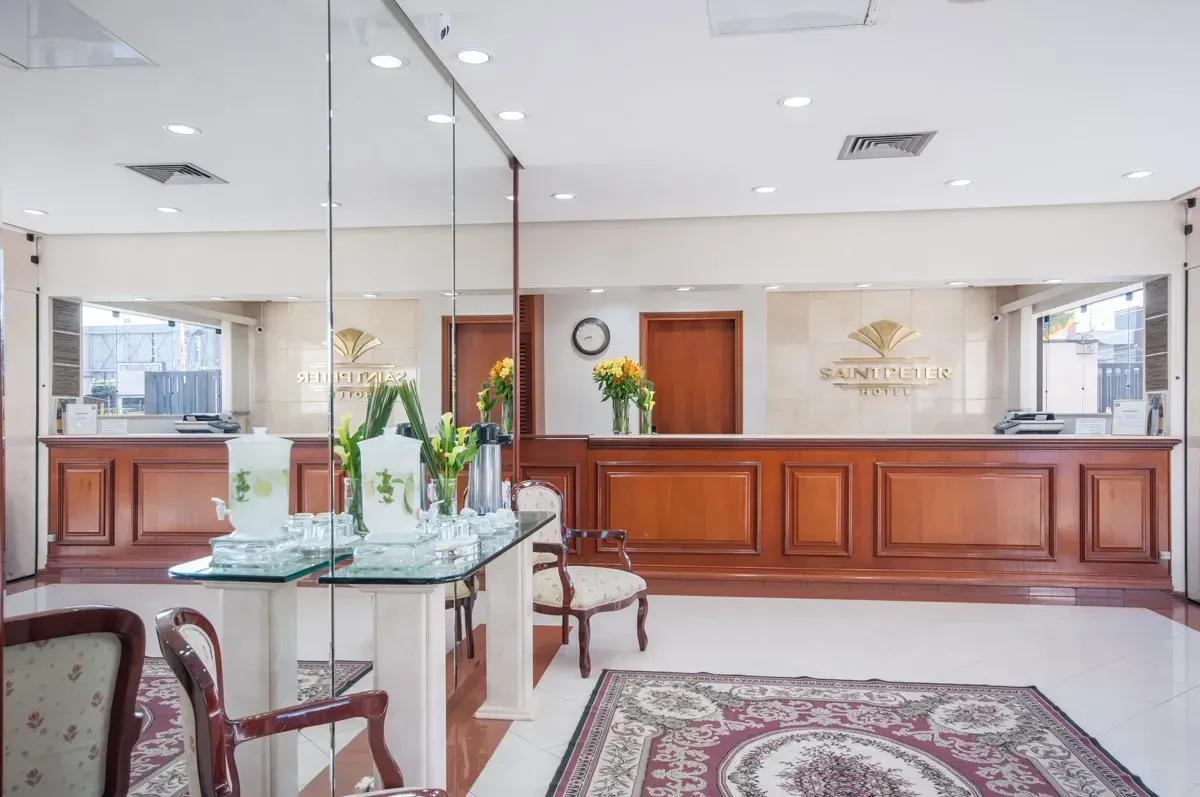 Um lobby de hotel com um grande balcão de madeira e cadeiras.