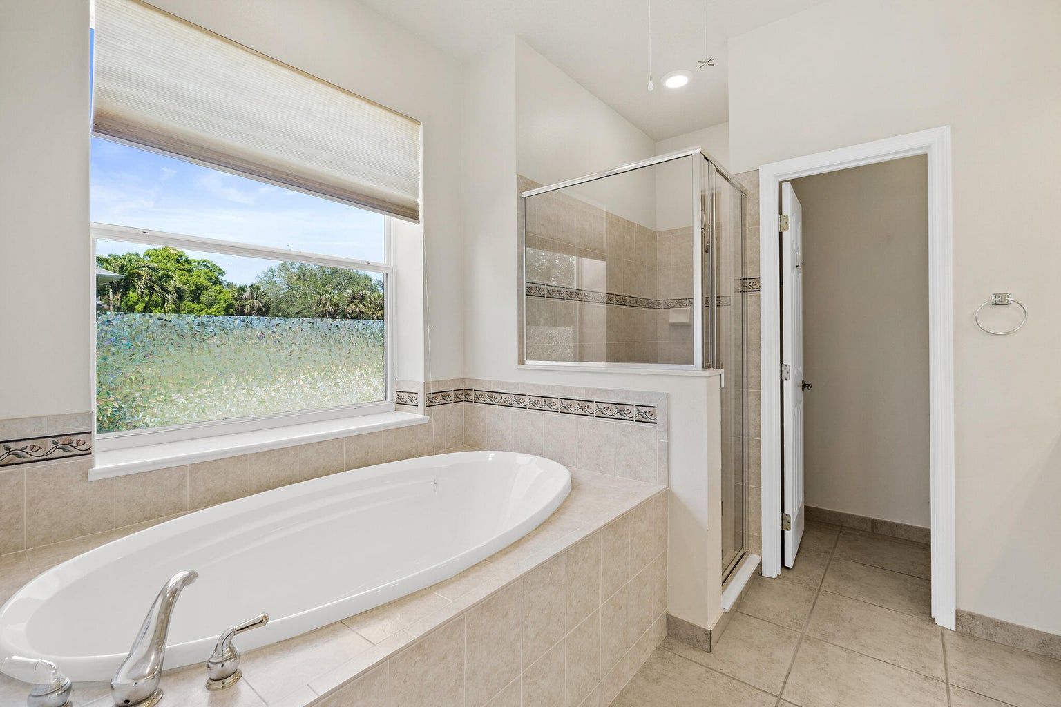 Open doorway revealing living room with light wooden floors, white walls, and artwork.