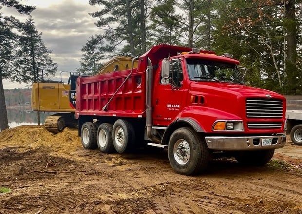 Red dump truck parked on dirt