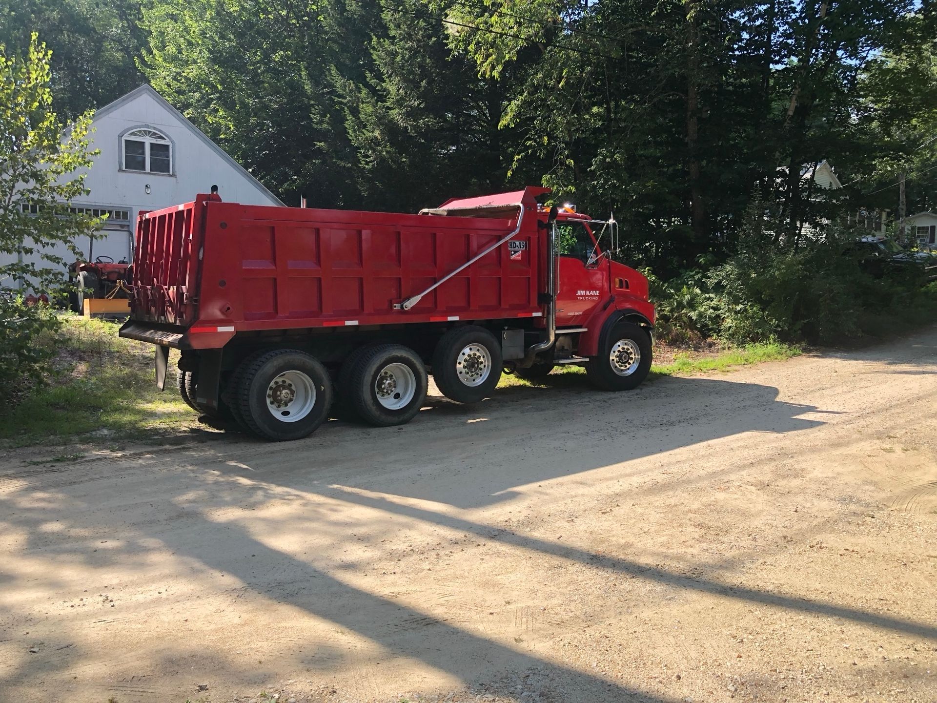 Red dump truck dumping dirt
