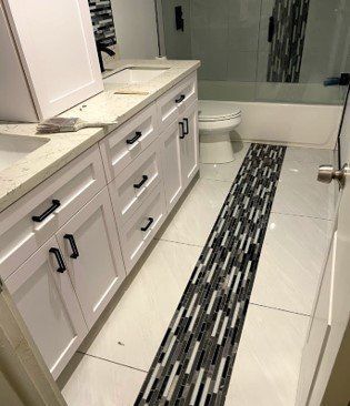 A bathroom with white cabinets , a toilet , and a bathtub.