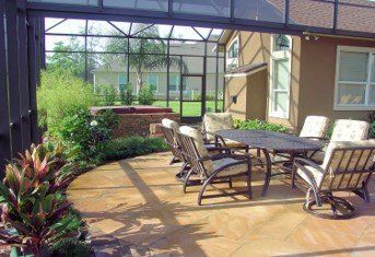 A patio with a table and chairs in front of a house.