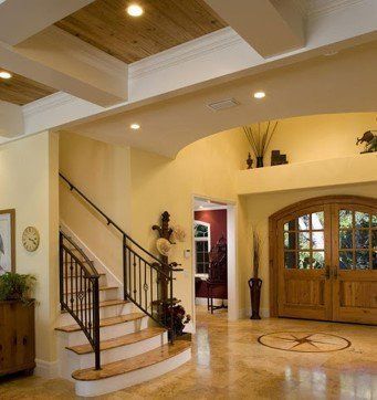A hallway with stairs and a clock on the wall