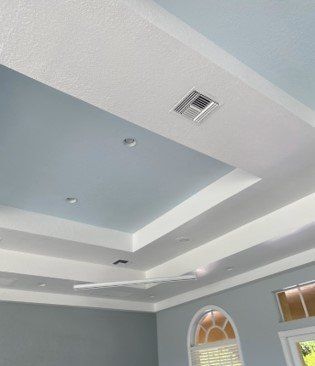 A room with a blue and white ceiling and a ceiling fan.