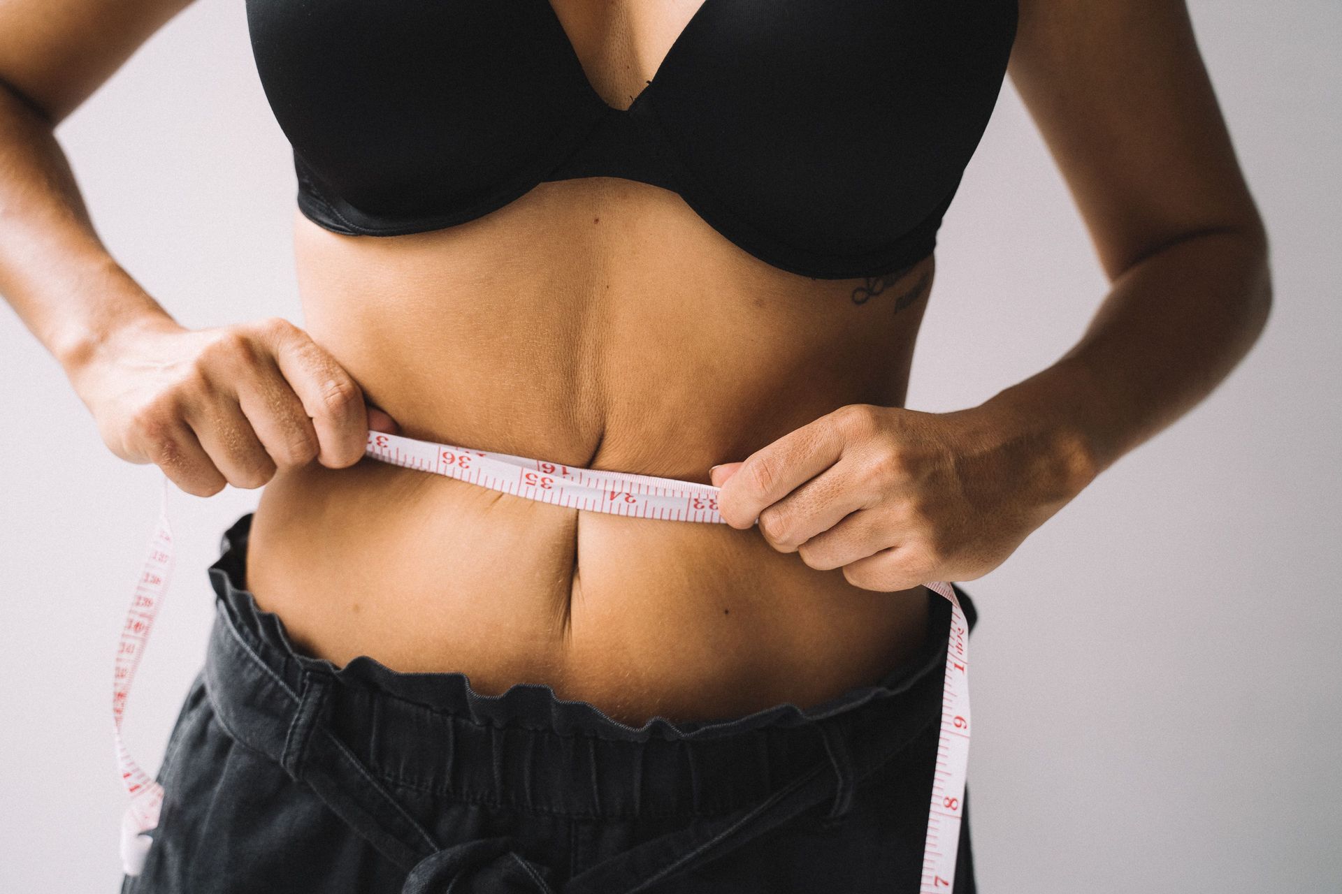 Person celebrating weight loss success while learning about emerging obesity medicine treatments and