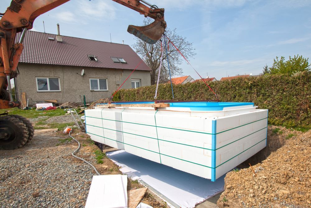 A Large Swimming Pool is Being Built in Front of a House — Clarence Valley Pools In Grafton, NSW