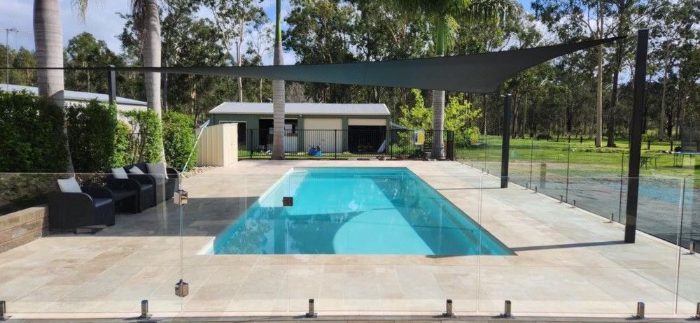 A rectangular pool with turquoise water, a shaded area, and a grassy area in the background — Clarence Valley Pools In Yamba, NSW