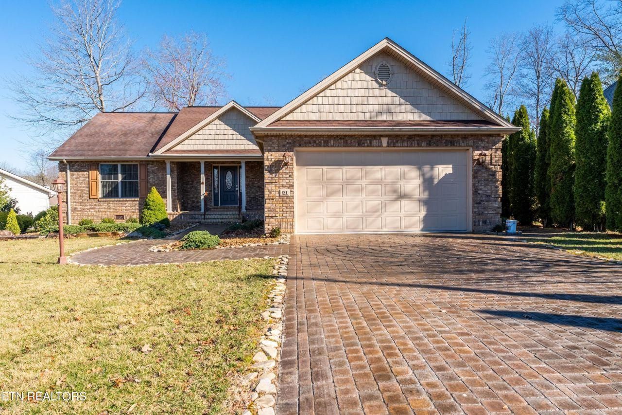 A house with a brick driveway in front of it.