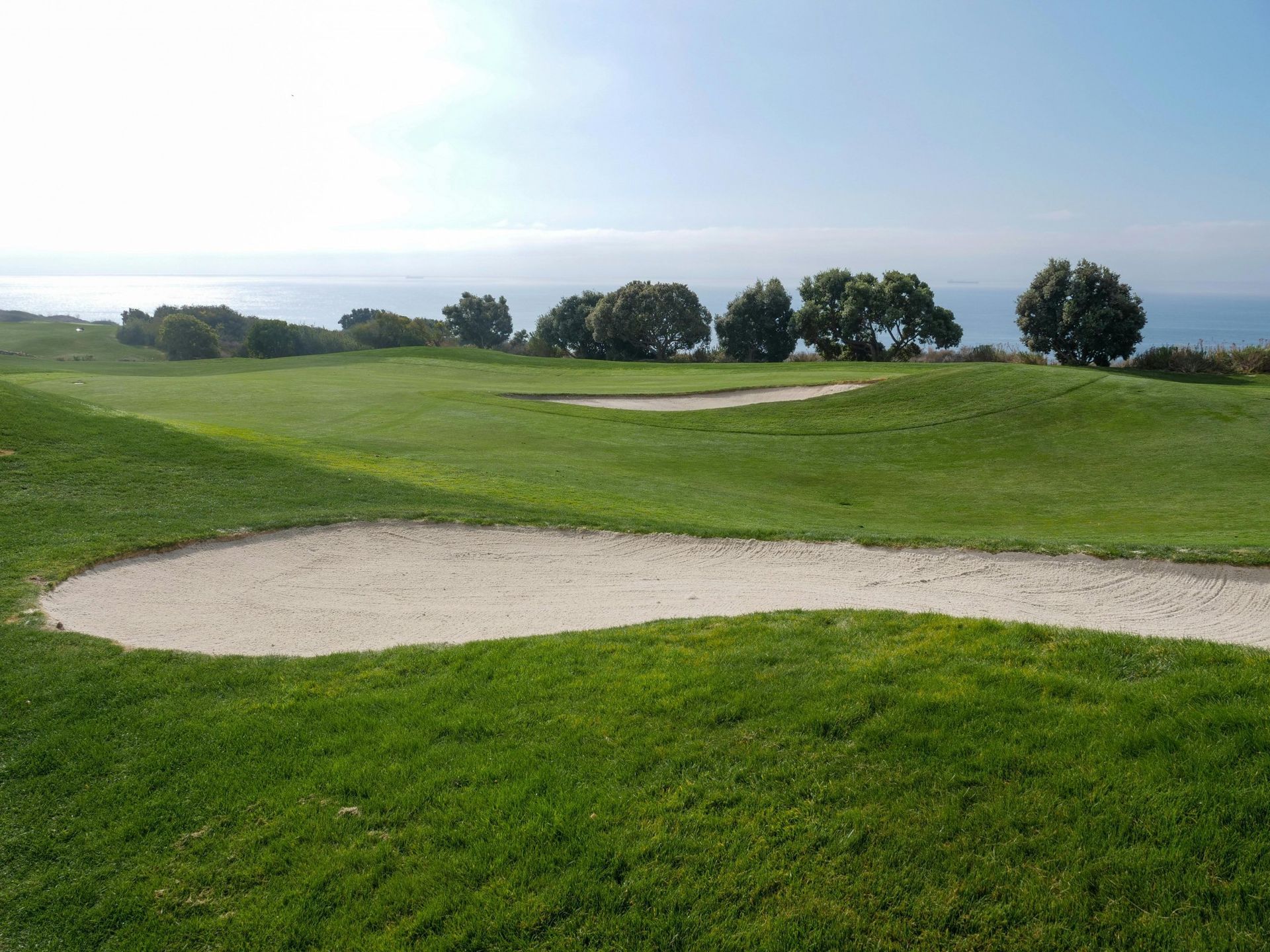 A golf course with a bunker in the middle of it