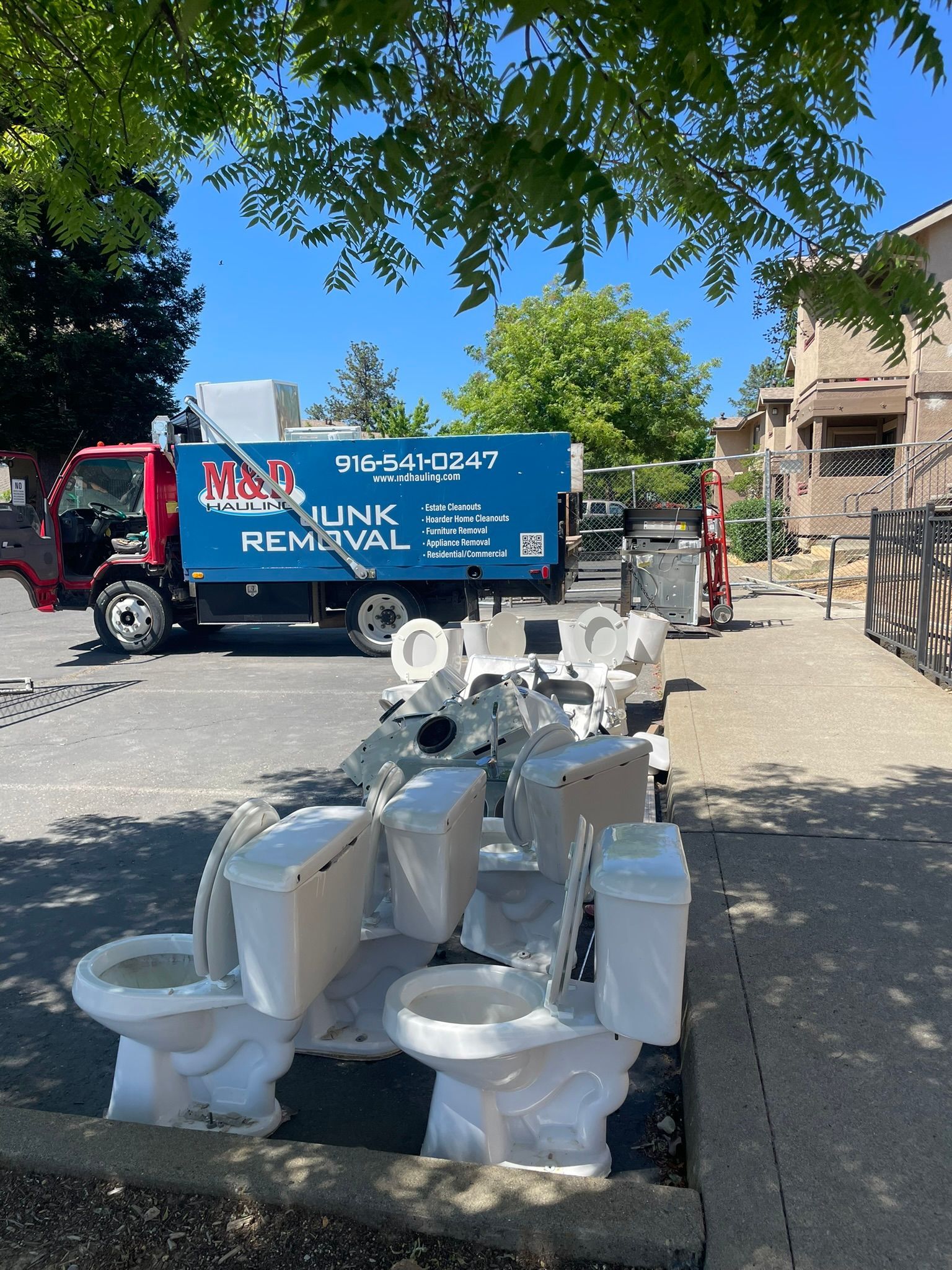 A junk removal truck is parked on the side of the road.