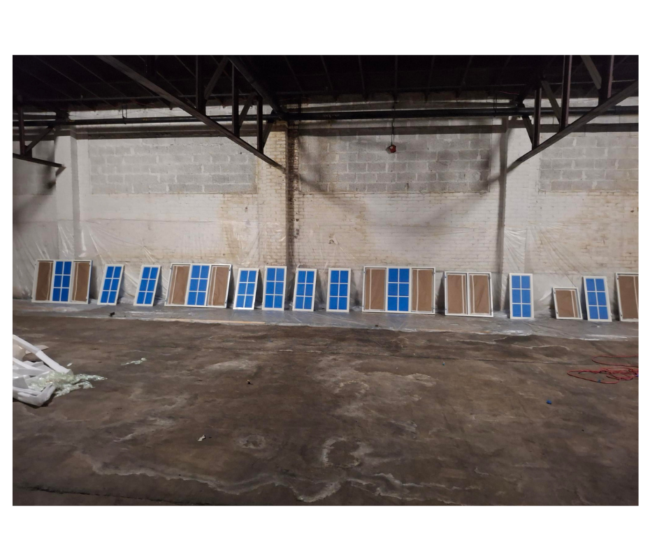 Two men are installing a sliding glass door in a room.