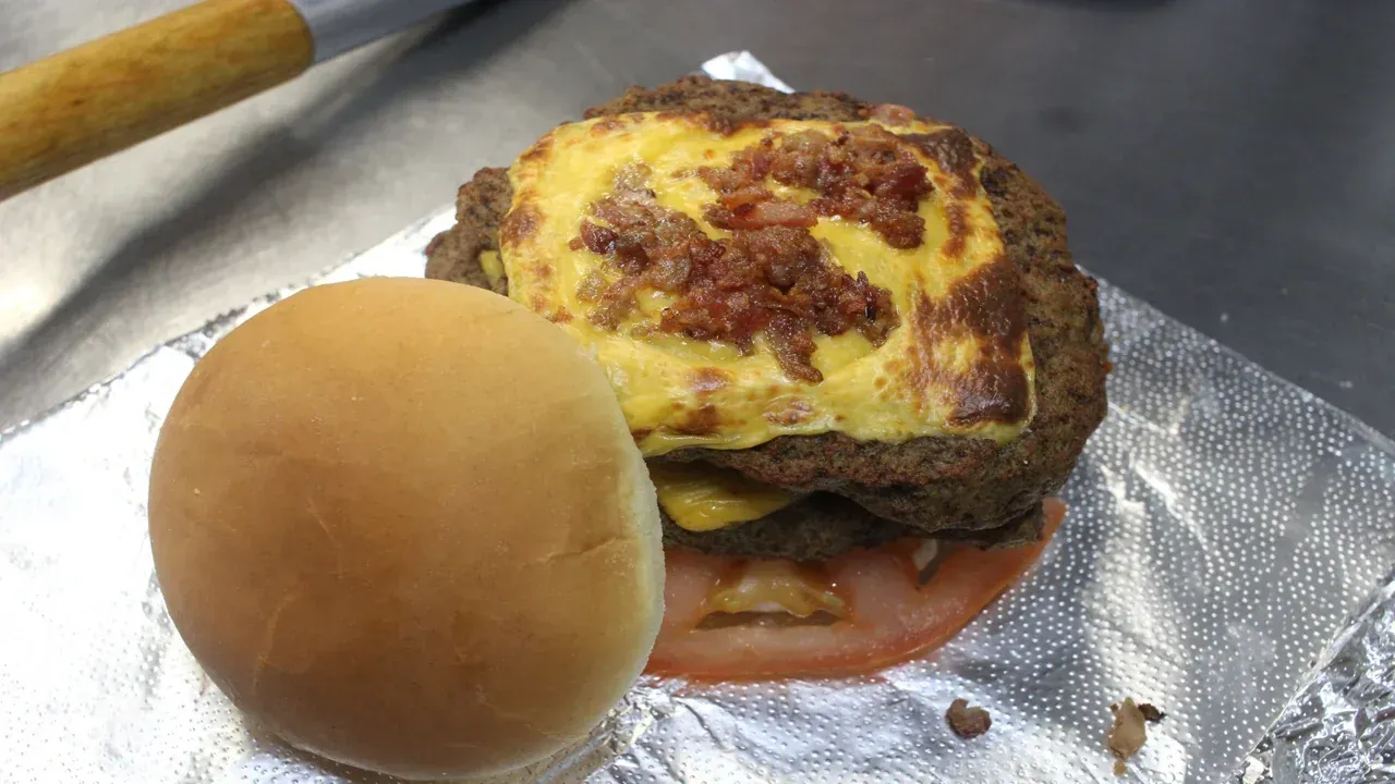 Hamburger with cheese, bacon, tomato, and bun.