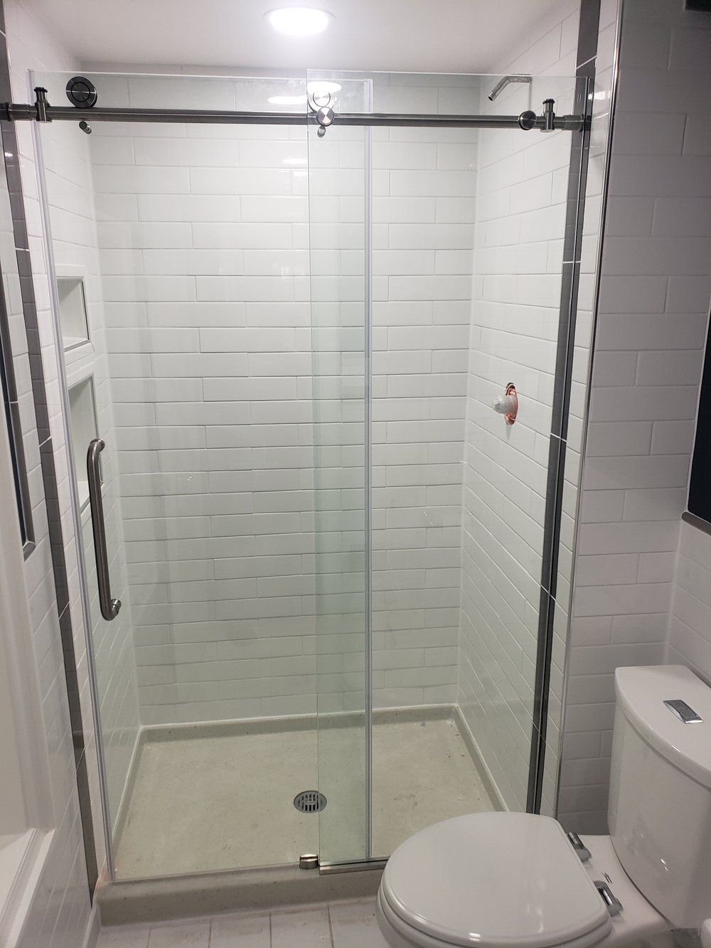 A bathroom with a sliding glass shower door and a toilet.