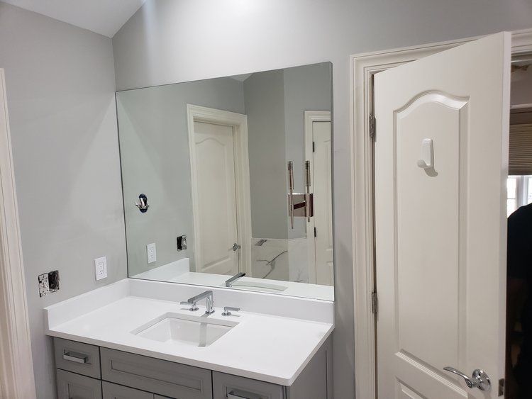 A bathroom with a sink and a large mirror.