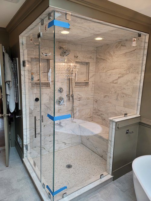 A bathroom with a walk in shower and a bathtub.