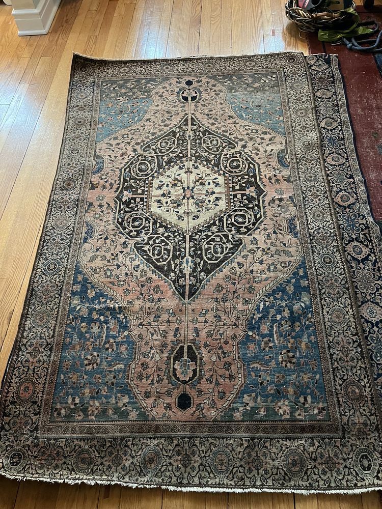 A rug is sitting on top of a wooden floor.